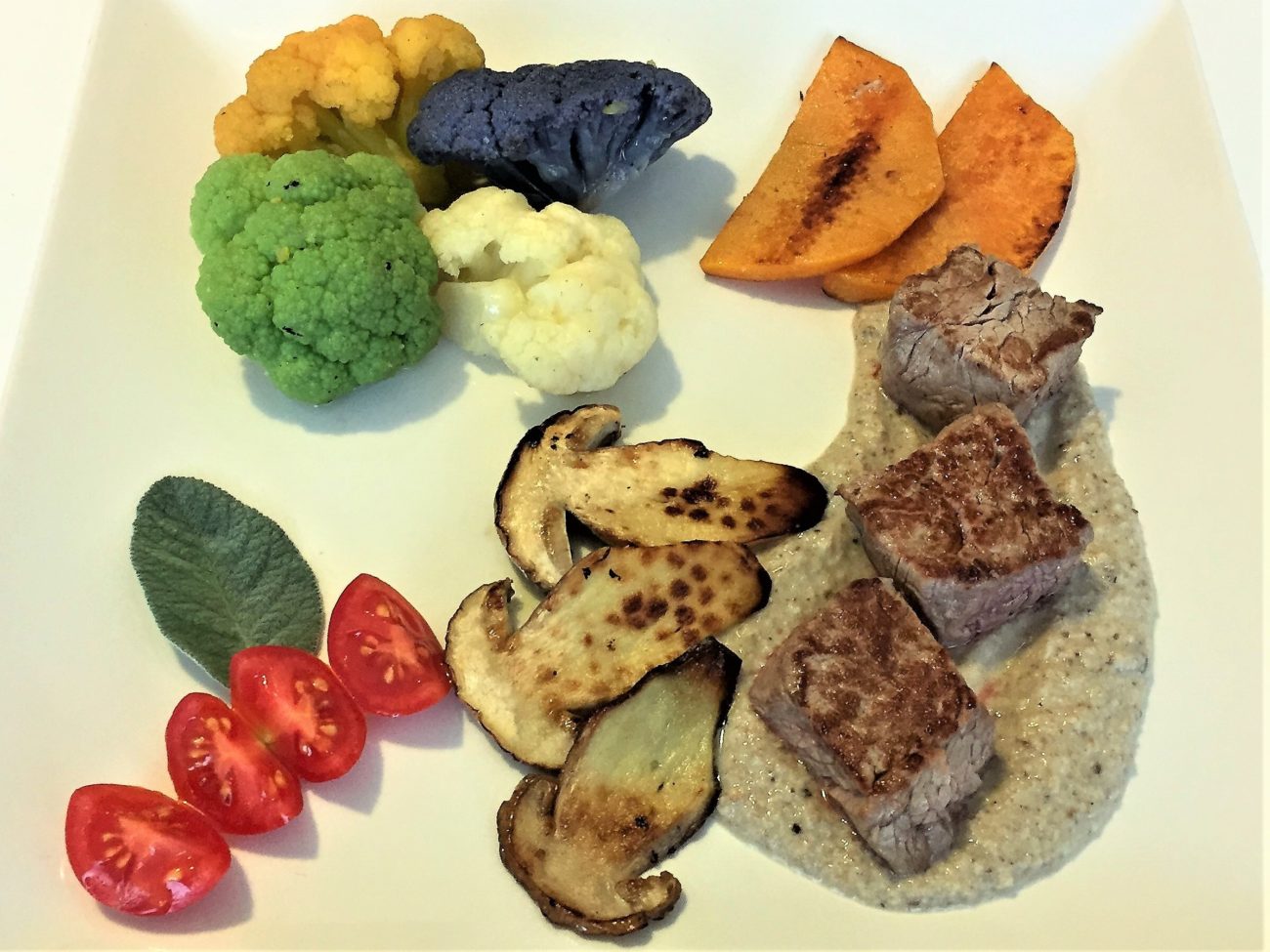 Cubetti di filetto di manzo su crema di porcino con tris di cavolfiori e zucca ai ferri