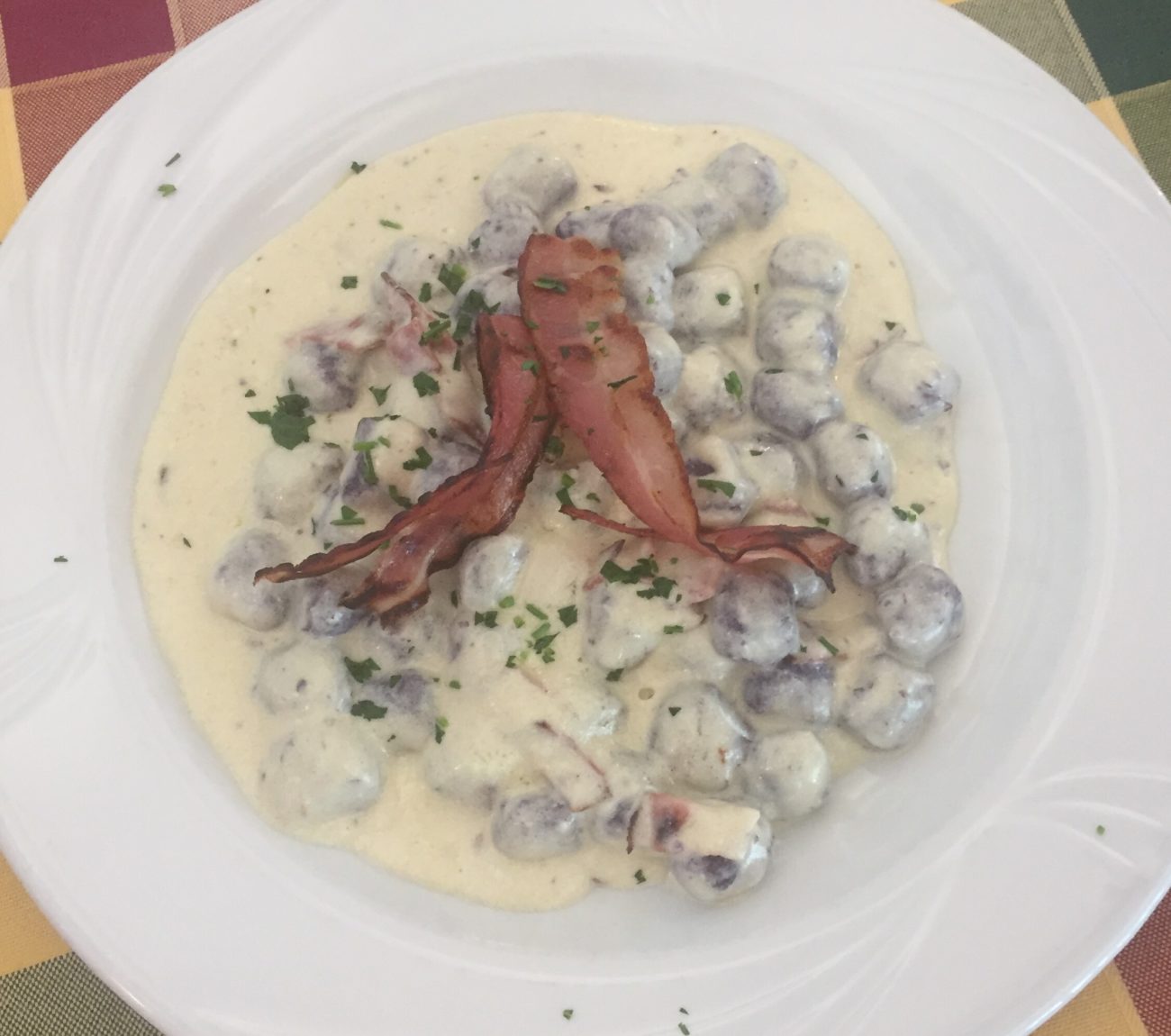 Gnocchi di barbabietola con crema di montasio e speck