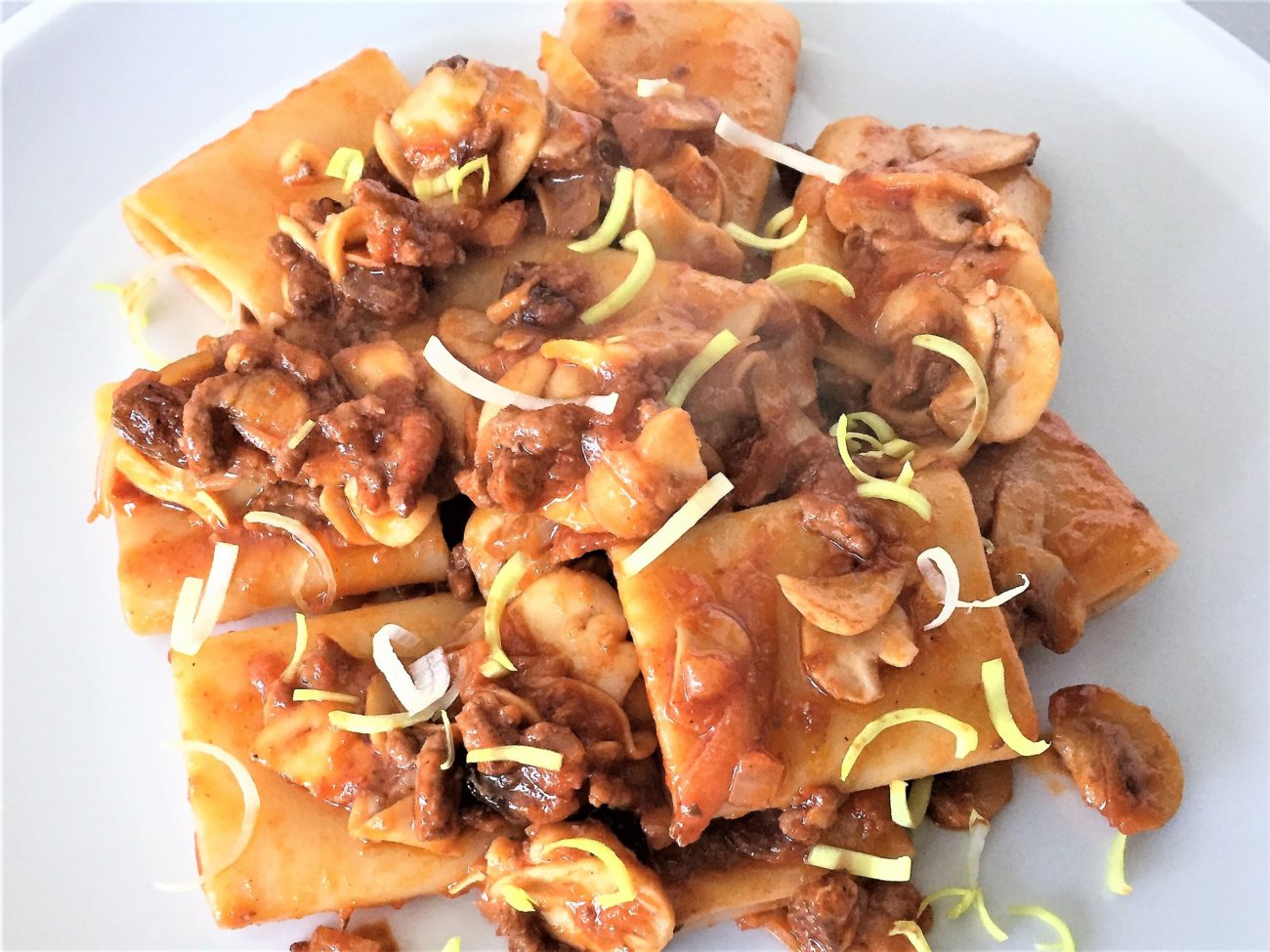 Paccheri con ragù uva passa e champignon