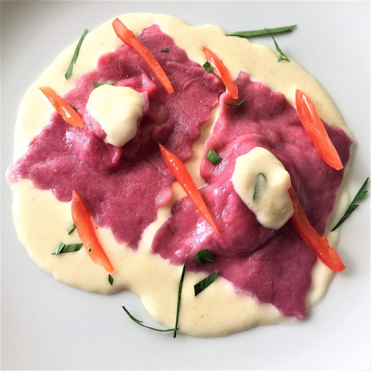 Ravioli di barbabietola con ripieno di funghi e salsa di grana padano