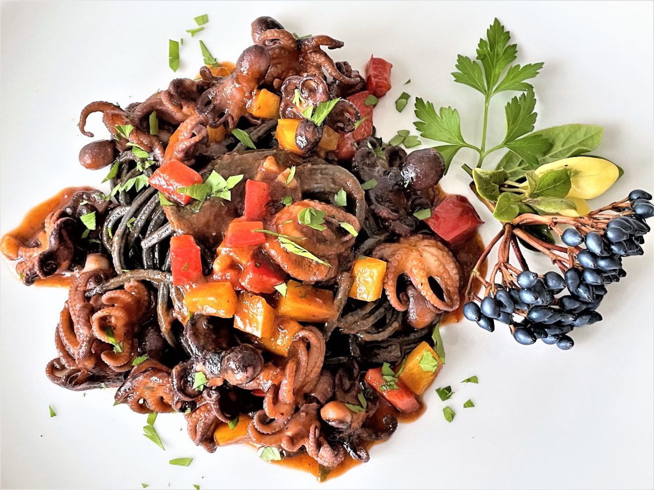 Spaghetti al nero di seppia con moscardini e peperoni