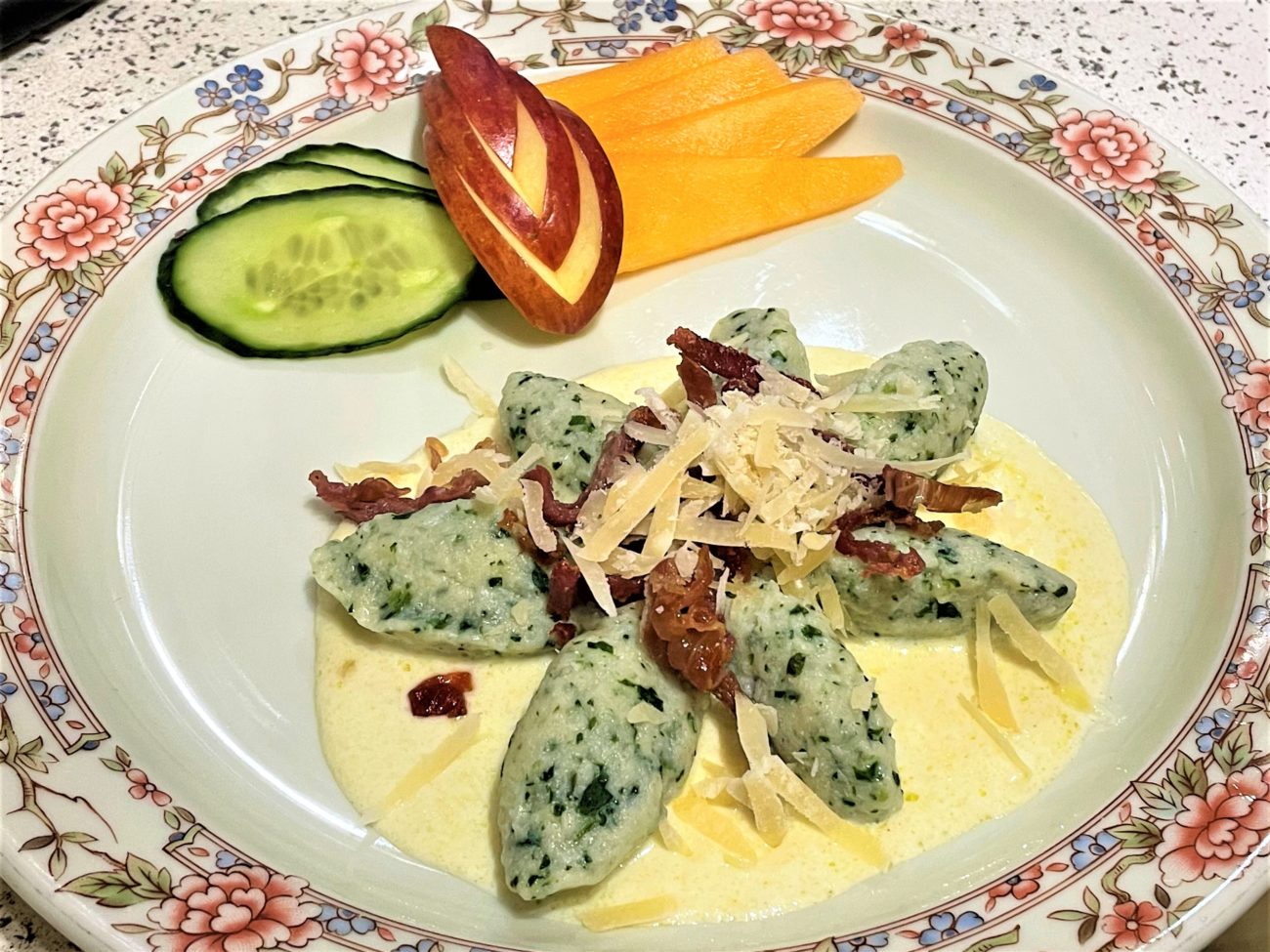 Chenelle di ricotta e spinaci con crema di parmigiano e speck croccante