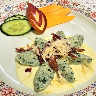 Chenelle-di-ricotta-e spinaci-con-crema-di-parmigiano-e-speck-croccante